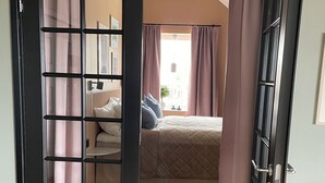 A bedroom with a bed, a nightstand, and a window with curtains. - Panoramic view near Gbg and nature (Västra Götalands län)