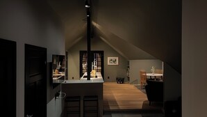 A modern kitchen with a central island, a dining area with a round table and chairs, and a visible staircase leading to an upper level. - Panoramic view near Gbg and nature (Västra Götalands län)