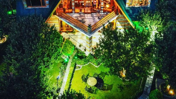 Une maison de forme triangulaire, dotée d’un intérieur spacieux, de panneaux solaires et d’un espace extérieur bien éclairé.
