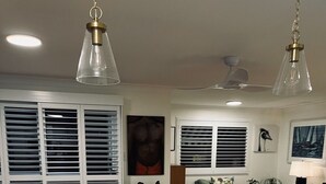 Cocina moderna con encimera blanca, grifo dorado e iluminación colgante.