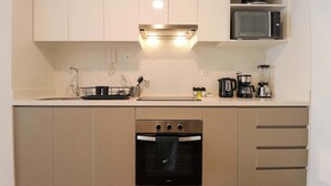 Een moderne keuken met een magnetron, oven en diverse apparaten.