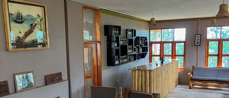 Quarto com mobiliário de madeira, espaço de bar e obras de arte nas paredes.