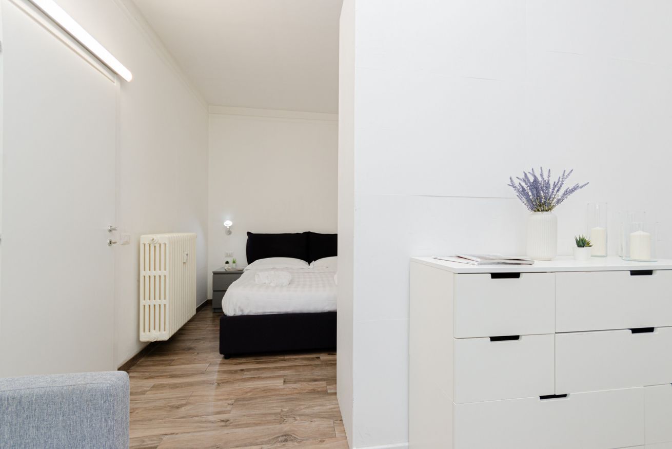 Ein modernes Schlafzimmer mit einem Bett, einem Nachttisch und einer Kommode mit Schubladen.