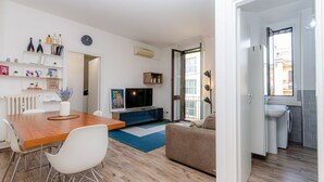 A modern apartment with a dining area, living room, and kitchenette. - VivimiHome - Stelvio House (Milano)
