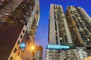 A modern high-rise building with a glass facade and multiple balconies. - Chic City Views Modern Comfort Near Southern Cross (Melbourne)