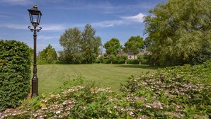 A well-maintained lawn with a classic street lamp and lush greenery. - Cozy apartment in a former farm within walking distance of the center of Workum (Workum)