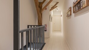 A narrow hallway with wooden beams, a black railing, and a fire extinguisher on the wall. - Cozy apartment in a former farm within walking distance of the center of Workum (Workum)