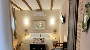 A cozy hotel room with a bed, a desk, a chair, a suitcase, and a wardrobe. - La Cascina di Bea (Torre Boldone)
