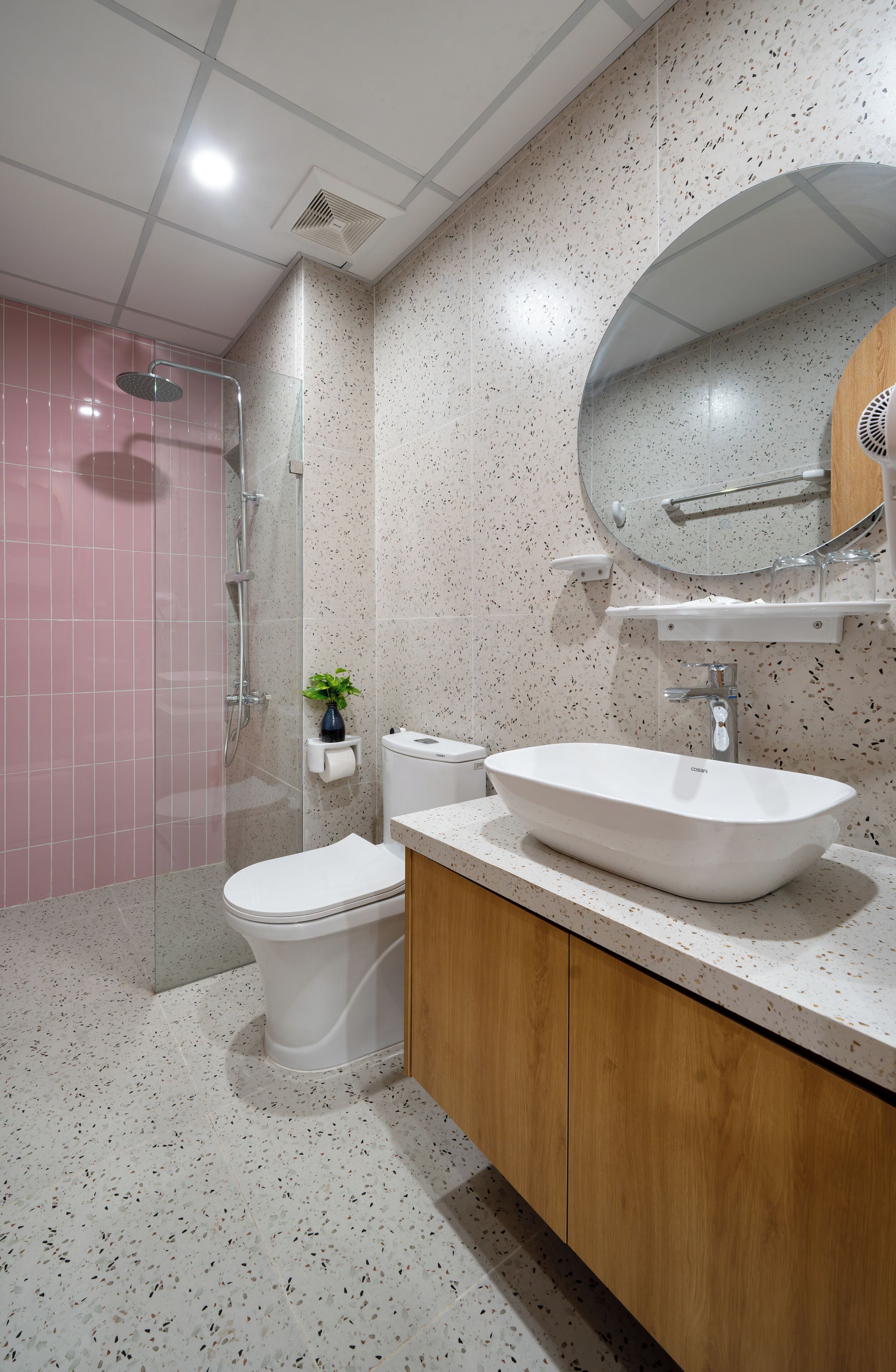 A bathroom with a white sink, a mirror, a toilet, and a shower.