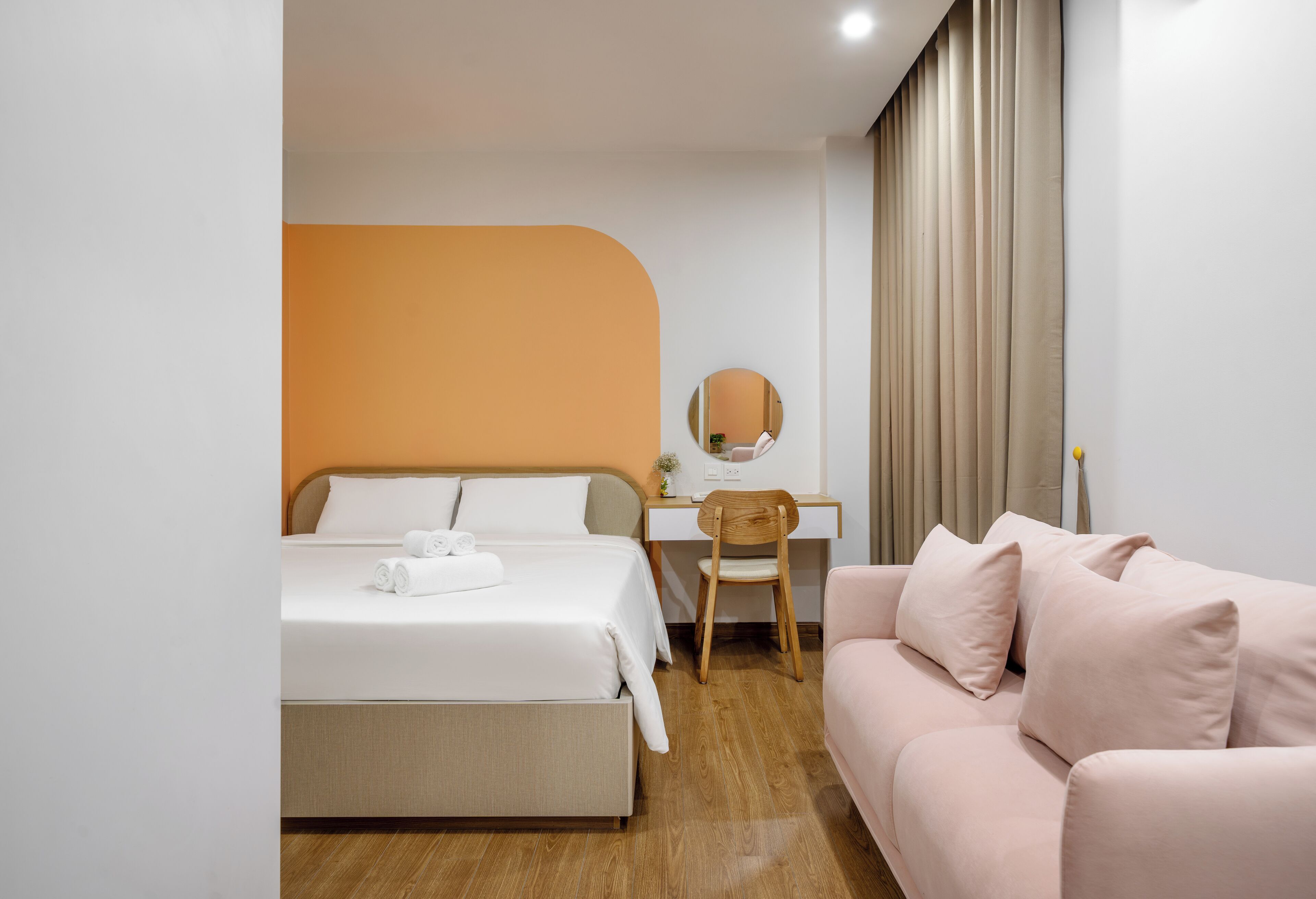 A hotel room with a bed, a desk, a chair, and a sofa.
