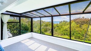 A room with large windows, a white ceiling, and a view of a forest. - Enjoy Your Private SPA with Stunning Tranquil View (Auckland)