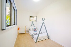 A bedroom with a bed, a window, a radiator, and a wall-mounted shelf. - Enjoy Your Private SPA with Stunning Tranquil View (Auckland)