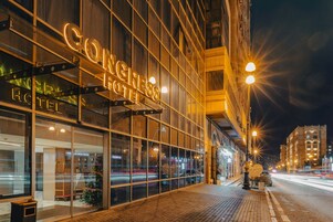 Een hotel met een groot verlicht bord waarop 'Congress Hotel' staat.