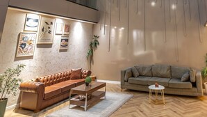 Een ruime atrium met een hoge plafond, moderne meubels en kunstwerken aan de muren.
