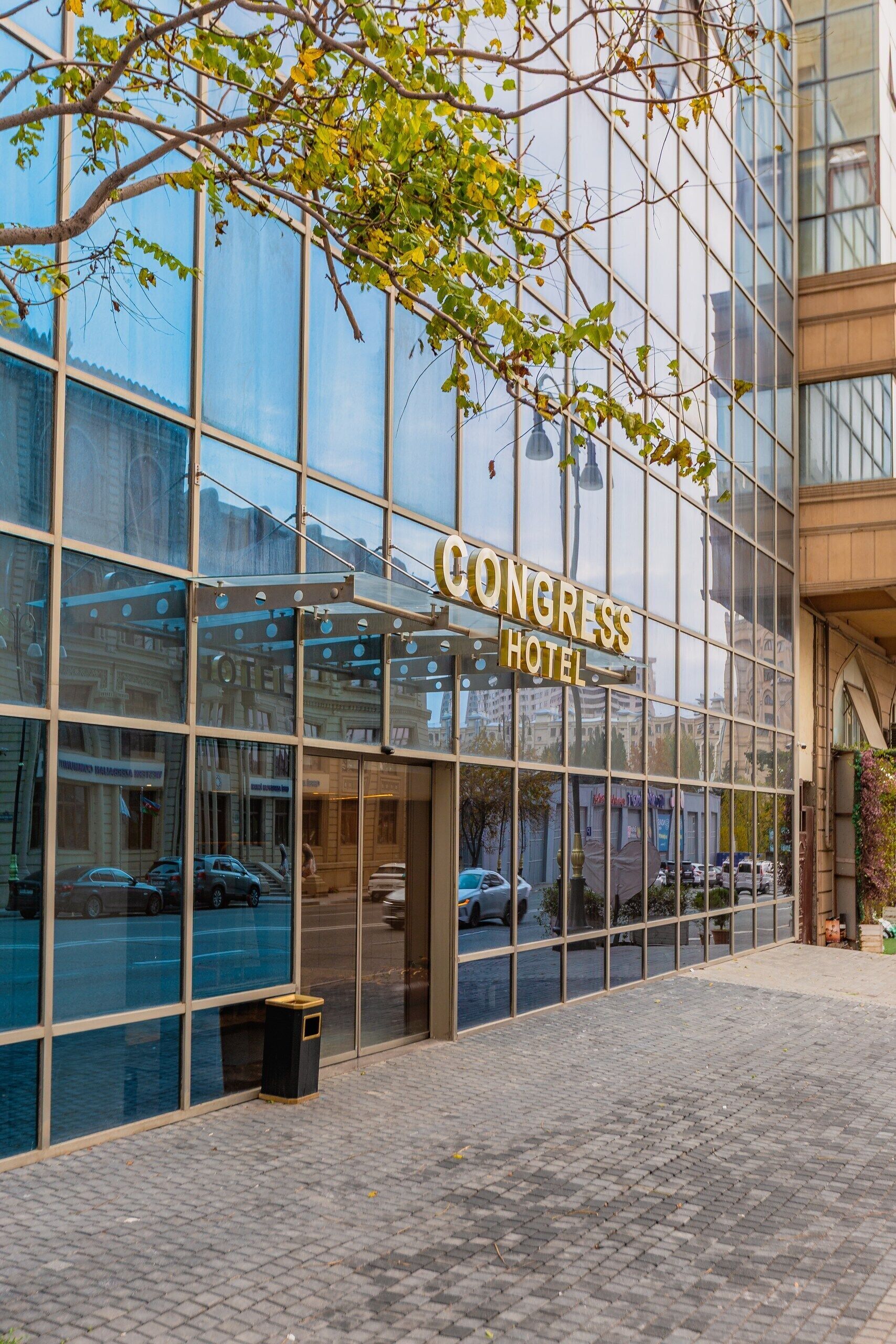A modern building with a large glass facade and a sign reading "CONGRESS HOTEL".