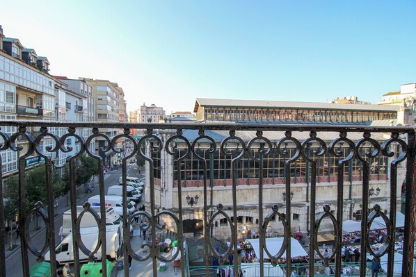 A view of a city street with buildings, a market, and a clear sky.