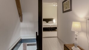 A hallway leading to a bedroom with a bed, a bedside lamp, and a framed picture on the wall. - Flat (max 4 pers) in former farmhouse within walking distance of Workum centre (Workum)