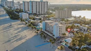 Zona hotelera costera con varios edificios altos, una playa y palmeras.