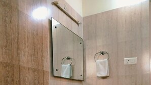A bathroom with a toilet, sink, and mirror. - The Stem (Hyderabad)