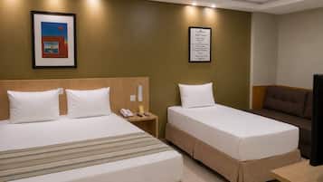 Habitación de hotel con dos camas, un escritorio, un televisor, un teléfono y una cita enmarcadas en la pared.