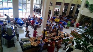 A crowded indoor event with tables, food displays, and people. - Hotel Maravilhoso-Banheira-PiscinaTermal (Caldas Novas)