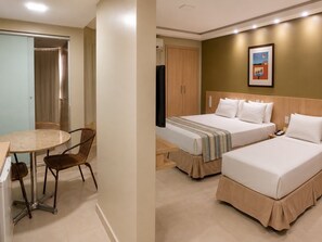 Une chambre d’hôtel avec deux lits, un bureau avec une chaise, une armoire et un tableau au mur.