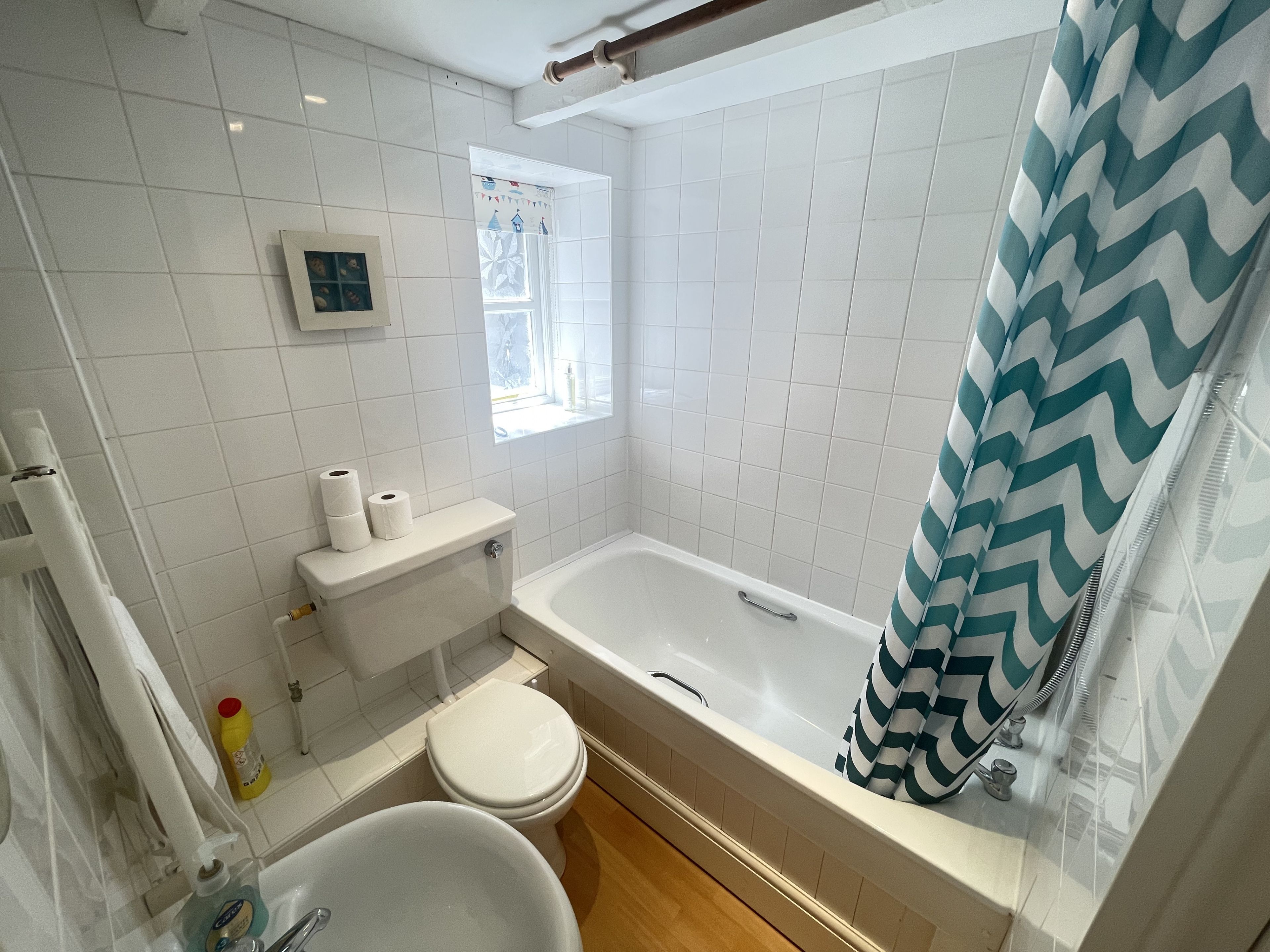 Een badkamer met een bad, toilet en wastafel.