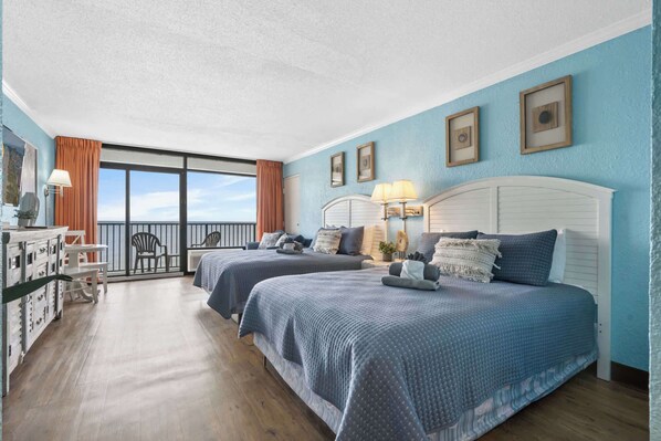 Ein Hotelzimmer mit zwei Betten, einem Balkon und Blick zum Himmel.