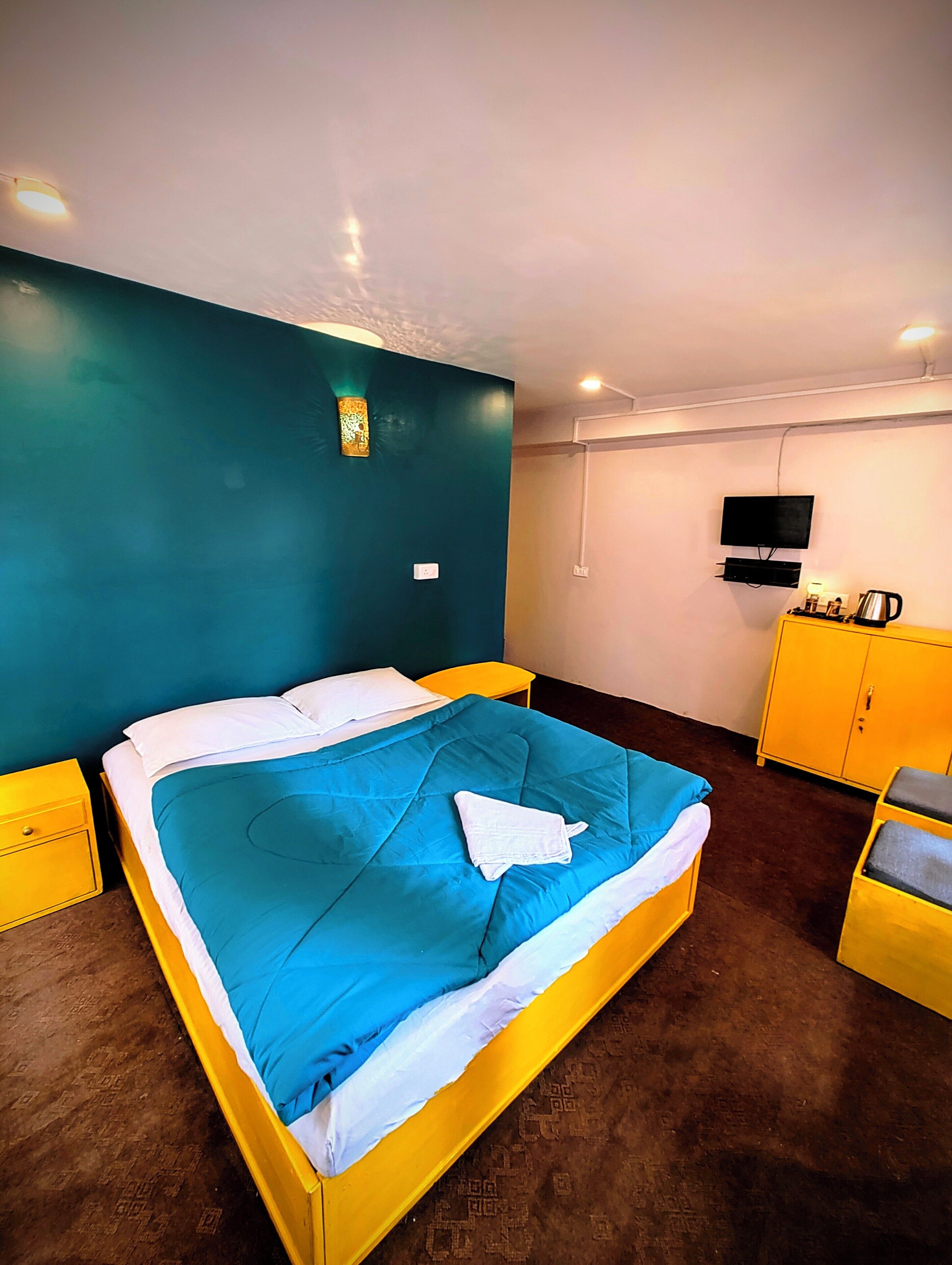 A room with a bed, a television, and a cabinet.