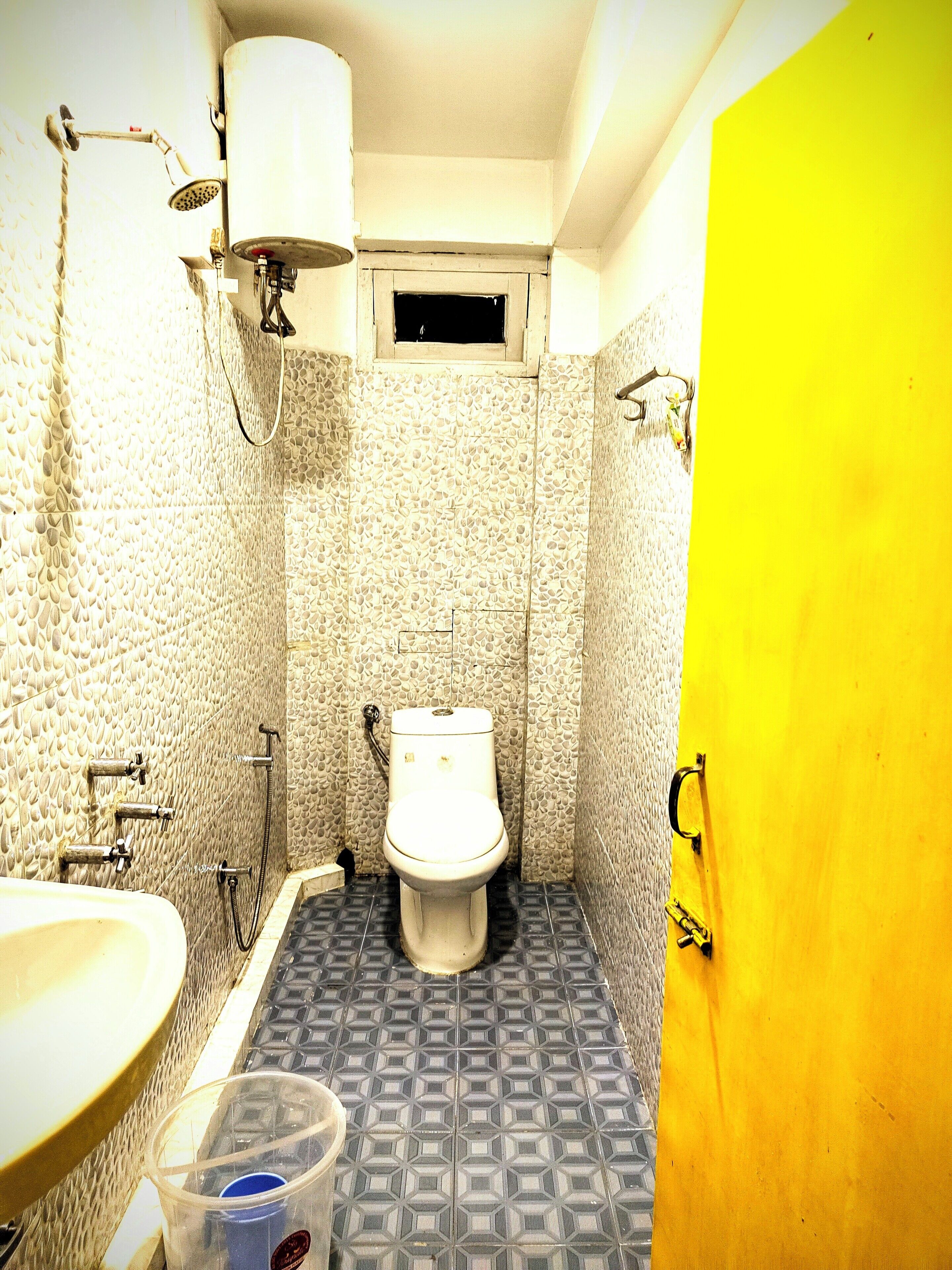 A small bathroom with a toilet, a sink, and a shower.