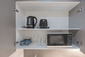 Kitchen area features a microwave, coffee maker, and storage for essentials.