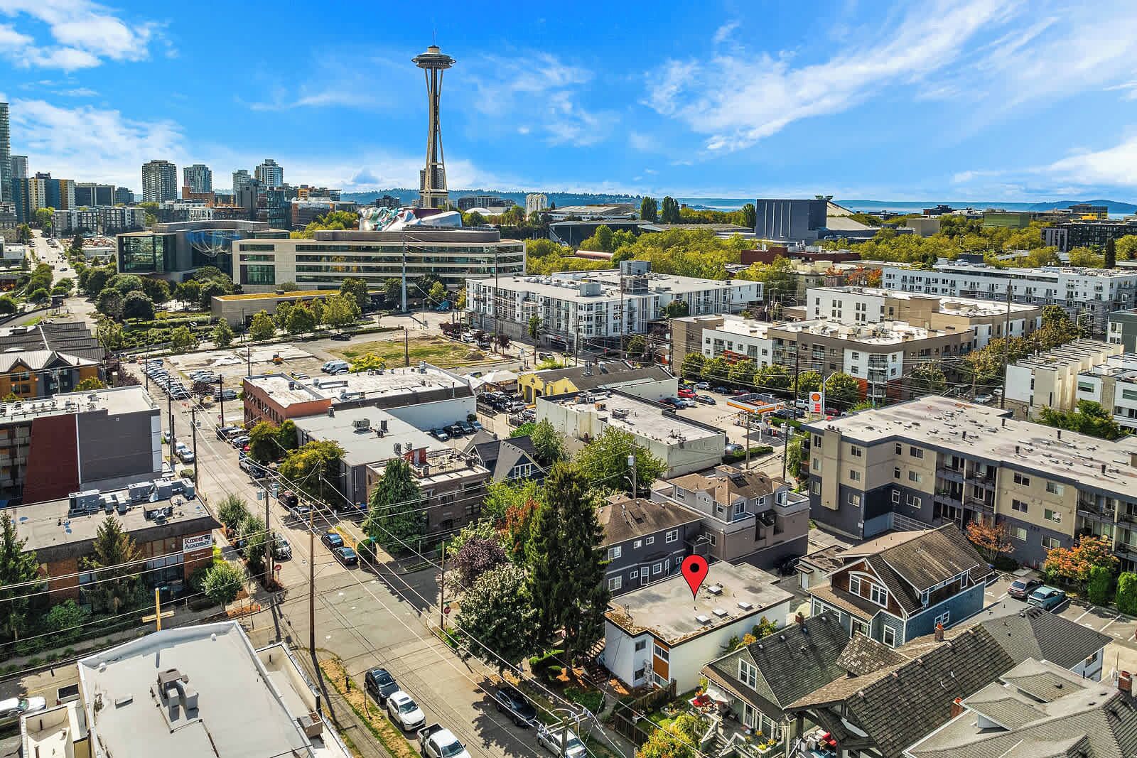 An aerial view of a cityscape with a prominent tower, various buildings, and a mix of residential and commercial structures.