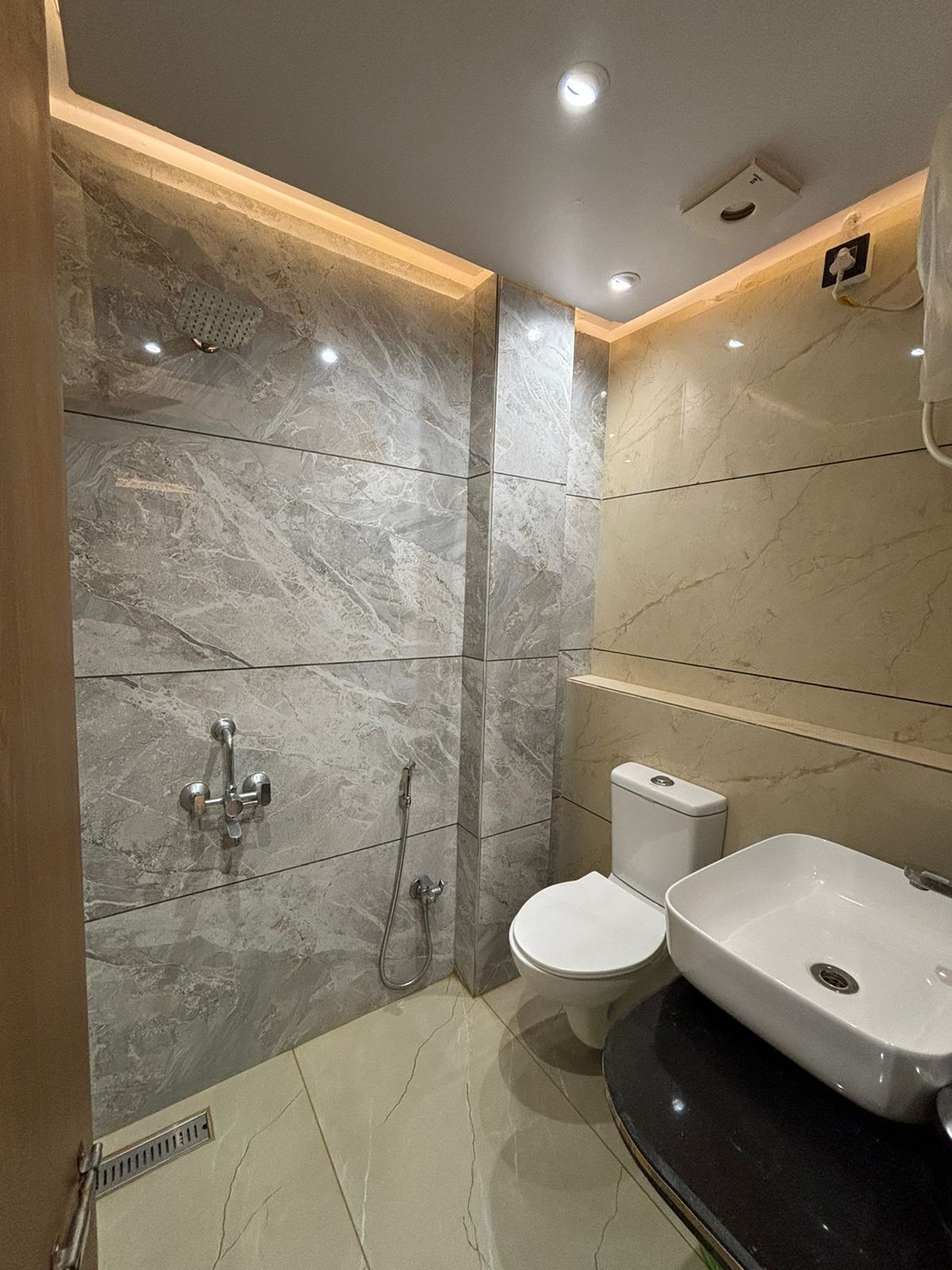A modern bathroom with a shower, toilet, and sink.