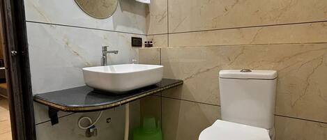 A bathroom with a sink, toilet, and a mirror.