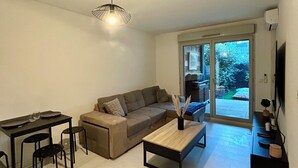 A modern living room with a sofa, coffee table, and dining area.