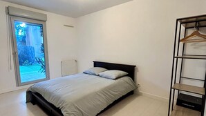 A bedroom with a bed, a window, and a built-in wardrobe.