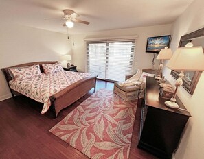 A bedroom with a bed, a chair, a desk, a ceiling fan, and a window with blinds. - Sea Winds 78 Oceanfront Beach Community (St. Augustine)