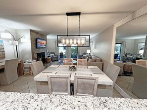 A modern dining area with a large table, chairs, and a chandelier. - Sea Winds 78 Oceanfront Beach Community (St. Augustine)
