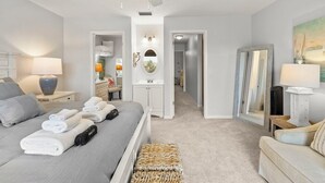 Ein Hotelzimmer mit Bett, Schreibtisch, Stuhl, Spiegel und einem Bild an der Wand.