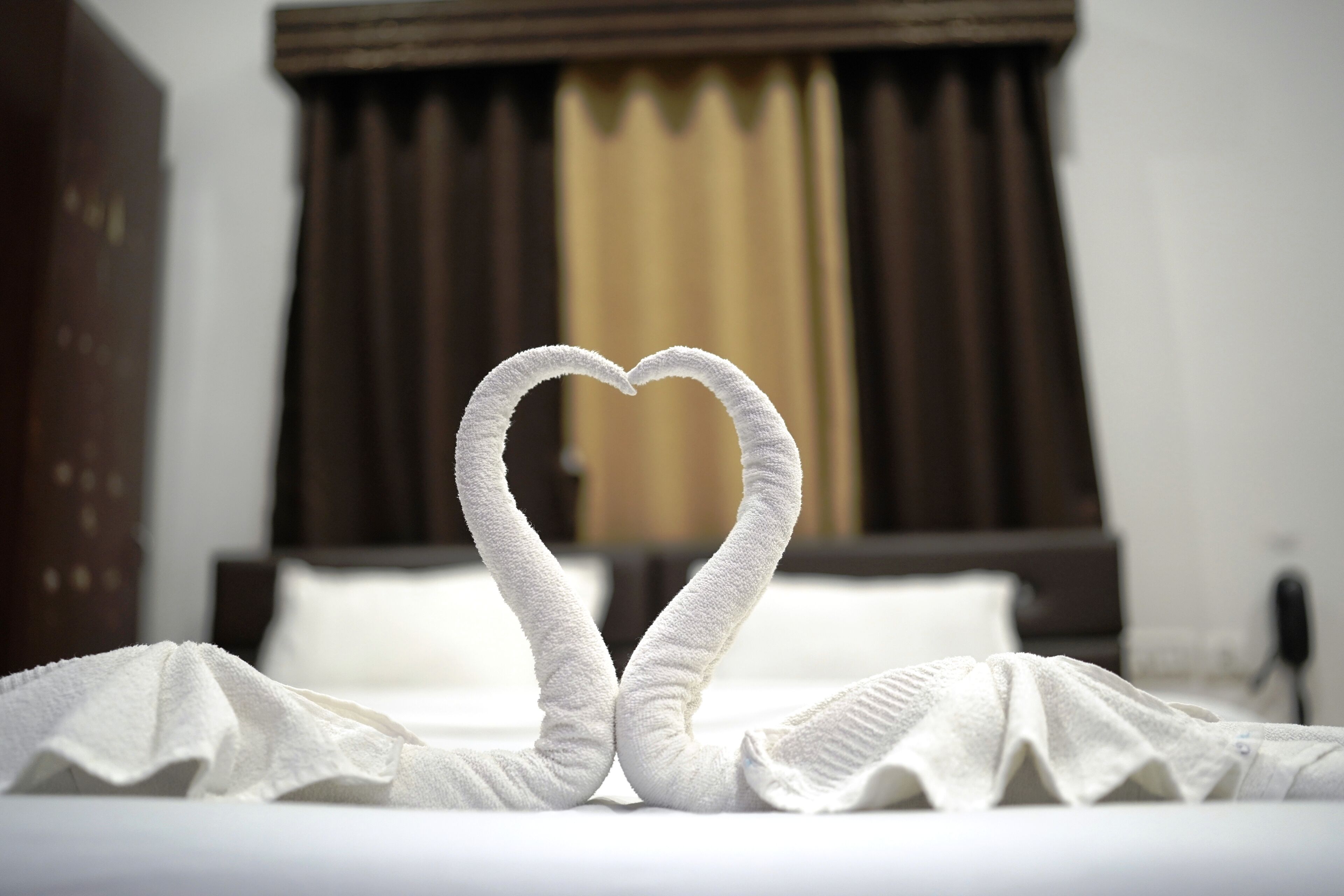 Ein Bett mit einer herzförmigen Handtuchgestaltung.