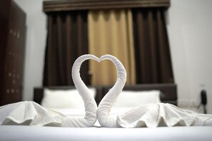 Een bed met handdoeken gevouwen in de vorm van een hart.