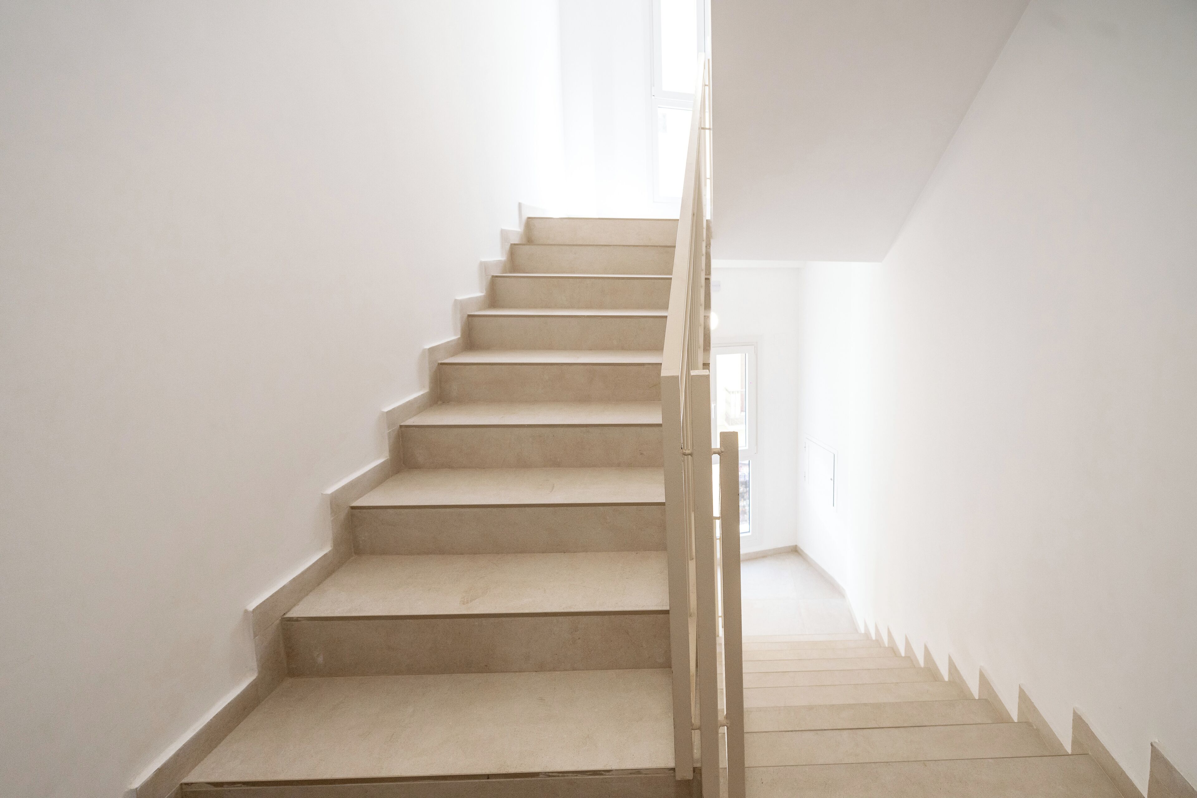 Una escalera con barandilla que conduce a un rellano.