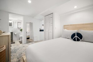 Relax in a spacious room with a large bed, bedside table, and closet.