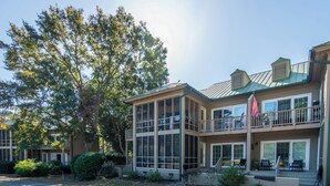 A two-story building with large windows, a balcony, and an American flag.