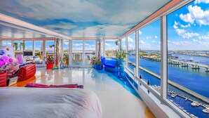 A spacious room with large windows offering a view of a marina and city skyline. - Disco Cloud Condo in Miami (Miami)