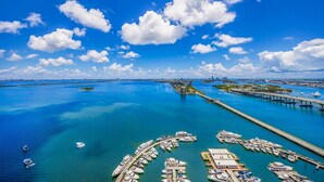 An aerial view of a marina with boats docked, a bridge, and a clear blue sky. - Disco Cloud Condo in Miami (Miami)