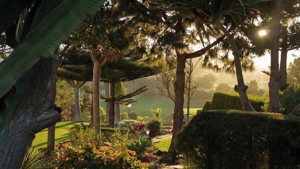 A lush garden with various trees and shrubs, a stone pathway, and a well-maintained lawn. - Bandama Golf Hotel by Airnest (Santa Brigida)