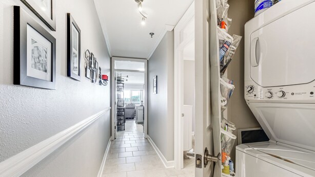 A hallway with framed pictures on the wall, a washing machine, and a door leading to a laundry room. - Beach + Pool Access: Smith Mountain Lake Getaway! (Huddleston)