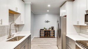 A modern kitchen with white cabinetry, a stainless steel sink, and a built-in coffee station. - 3 Mi to Camp Lejeune: Home w/ Fire Pit & Grill! (Jacksonville)