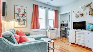A living room with a sofa, a coffee table, a TV, and a cabinet. - 3 Mi to Downtown Covington: Cozy Getaway w/ Porch! (Porterdale)